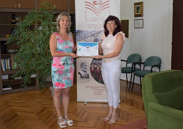 Maros Beáta átadja a minősítésről szóló tanúsítványt a főiskola rektorának.